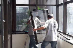 trabalhadores fazendo a manutenção da esquadria