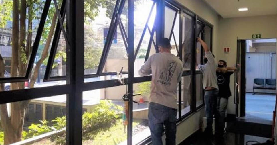 funcionários instalando a esquadrias fazendo analogia ao James Bond